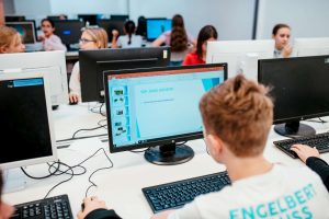 Lehrerin und Schüler an PCs (3)